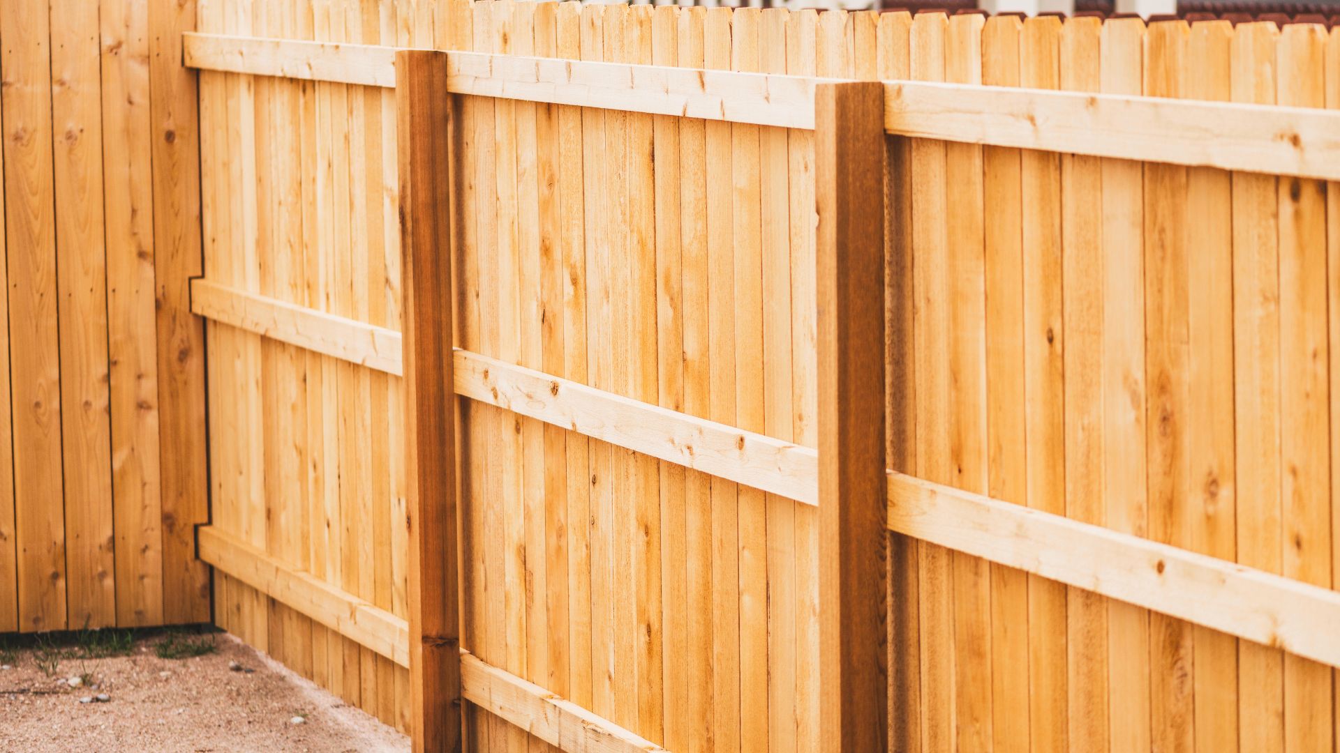 Wooden privacy fence with vertical planks and horizontal support beams