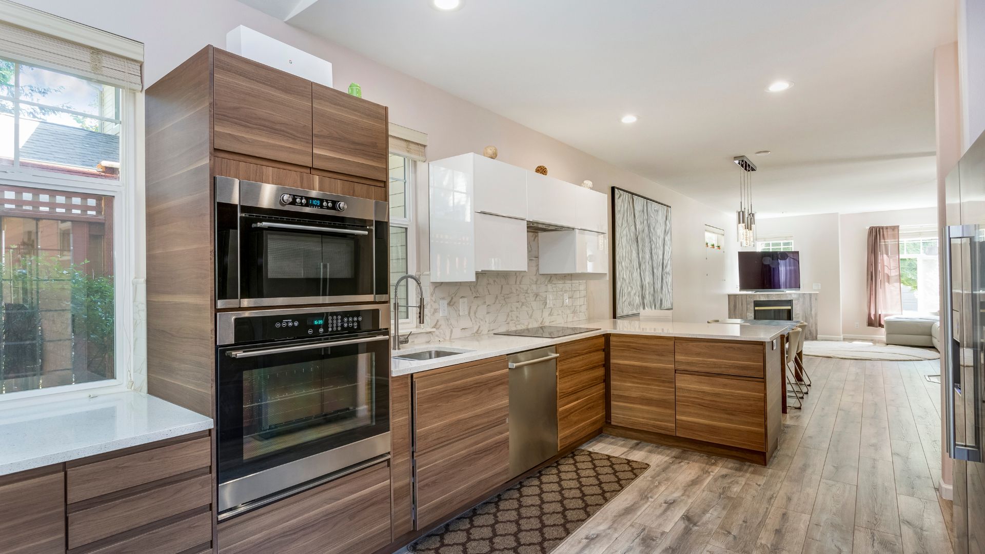 Modern kitchen with wood cabinets, stainless steel appliances, and white countertops